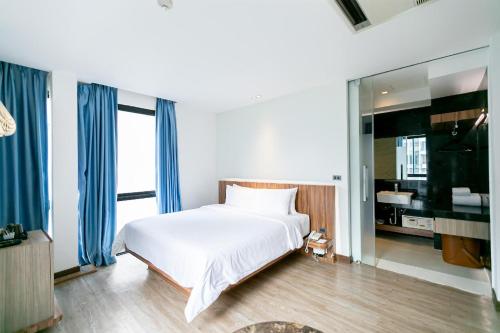 a bedroom with a white bed and a large window at UNO Express Asoke Sukhumvit Bangkok in Bangkok