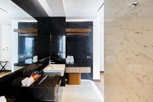 a bathroom with a sink and a black wall at Uno Express in Bangkok