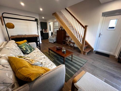 ein Wohnzimmer mit einer Couch und einer Treppe in der Unterkunft Bath Lane Cottages & Sauna Garden x8 beds in Newcastle