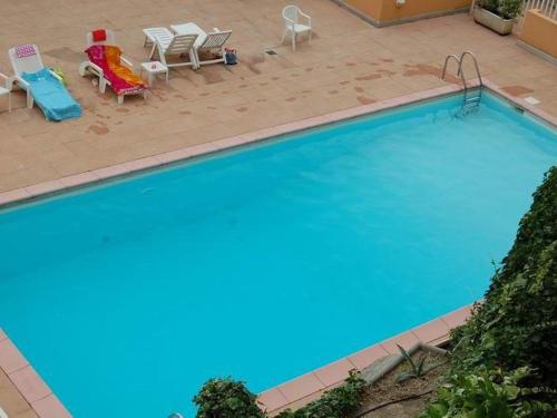 - une vue sur la grande piscine avec 2 chaises longues dans l'établissement Petit 3P avec terrasse, piscine et garage - FR-1-196-193, à Menton