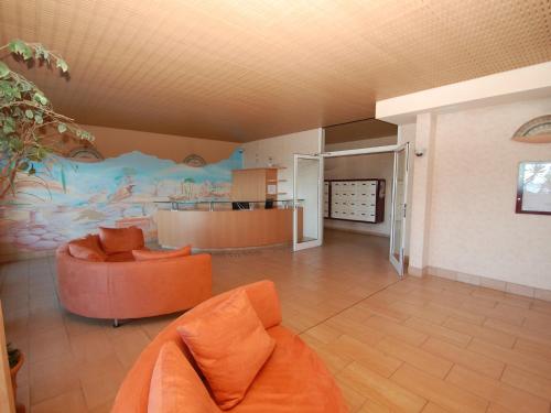 un salon avec un canapé orange et une peinture murale dans l'établissement Superbe 3P en bord de mer avec terrasse et garage à Menton - FR-1-196-248, à Menton