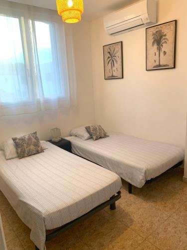 deux lits dans une chambre avec deux fenêtres dans l'établissement Villa climatisée de l'Etang de THAU avec piscine, à Sète