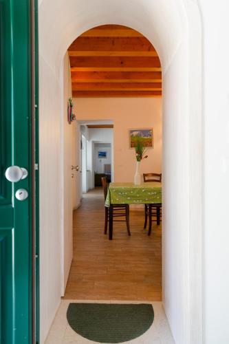 a hallway with a green table in a house at Albergo Diffuso Polcenigo C. Zoldan in Polcenigo