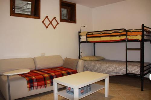 een woonkamer met een bank en een stapelbed bij Alpini Apartments in Chiesa in Valmalenco