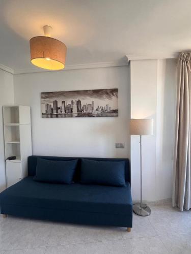 a living room with a blue couch and a lamp at Apartamento Exclusivo en la Playa 9 in Benidorm