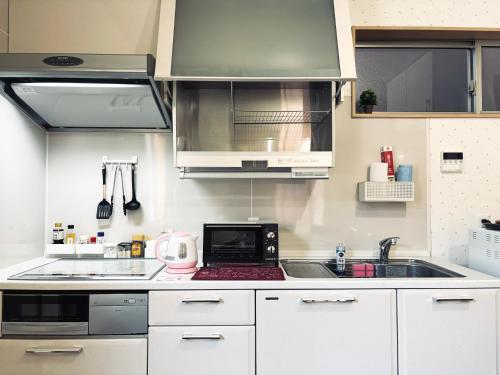 a kitchen with a sink and a microwave at 2024 Renovation house hanasaki in Takayama