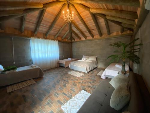 a large living room with two beds and a ceiling at Chalé Paradiso Biazolli in Farroupilha