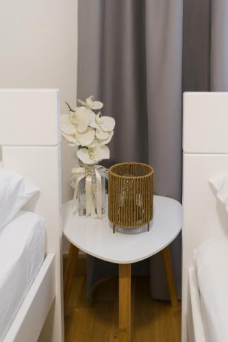 a white table with a vase of flowers on it at Apartman Krtalić in Međugorje