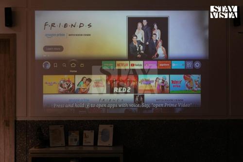 a flat screen tv with a movie on it at Corbett Calling with Projector Set-Up by StayVista in Rāmnagar