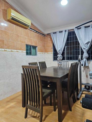 a dining room with a wooden table and chairs at Grace Homestay in Kudat
