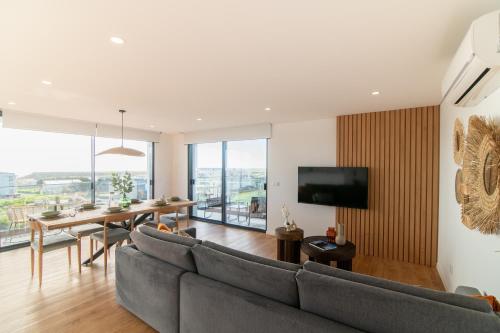 a living room with a couch and a table and a television at Priolo in Ponta Delgada - 4th floor apartment in Ponta Delgada