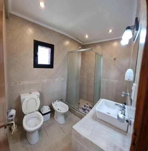 a bathroom with a toilet and a sink at Cabaña La Yuli in Santa Teresita