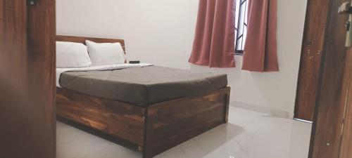 a bed with a ottoman in a room at Nirant Villa in Indore