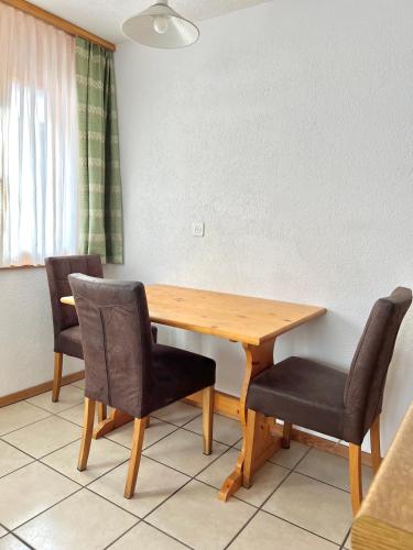 a wooden table and chairs in a room at Studio Relax in Lax