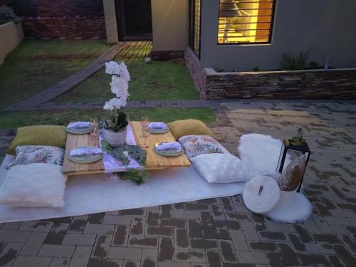 a picnic table with pillows and a tableablish at Mohau Accommodation and Events - South Africa in Elandsfontein