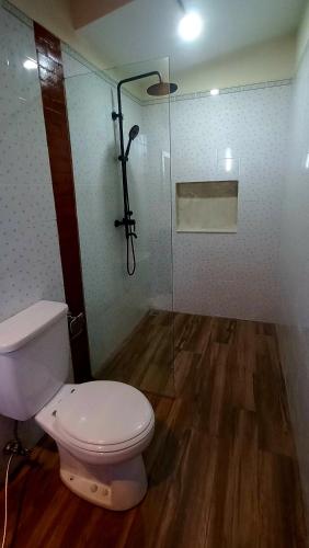 a bathroom with a toilet and a glass shower at Casa Shanti in Nusa Dua