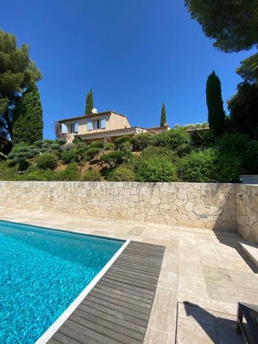 une maison au sommet d'une colline avec une piscine dans l'établissement Très belle villa vue mer - Piscine à débordement, à La Croix-Valmer