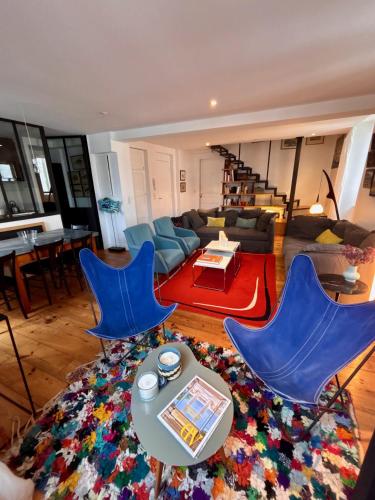 サン・ジャン・ド・リュズにあるDuplex T5 au pied de la plageのリビングルーム(青い椅子2脚、テーブル付)