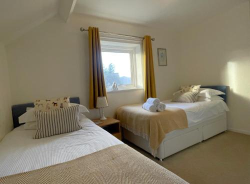 a bedroom with two beds and a window at Roslin in Portinscale