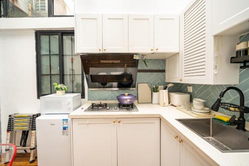 a kitchen with white cabinets and a stove top oven at 柃居 B&B - Jing'an Temple Branch in Shanghai
