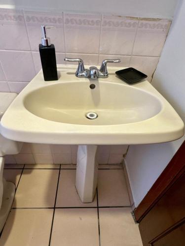 a white sink in a bathroom with a toothbrush at Exclusive Casa Platino Los Alamos in San Pedro Sula