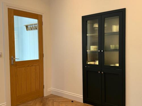 a room with a black cabinet and a door at Old Library Apartments 8b in Orkney
