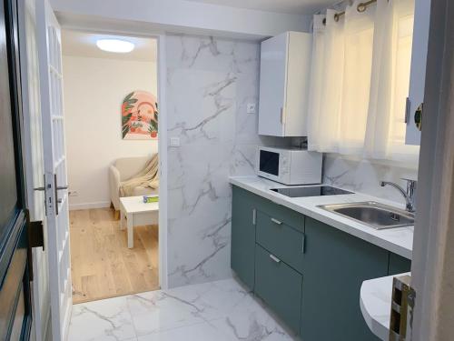 une cuisine avec un évier et un plan de travail dans l'établissement Cosy Apt with Paris Marais, à Paris