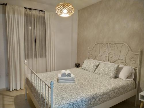 a bedroom with a white bed with a chandelier at Dúplex Chiclana Centro con Terraza y Parking By Chiclana Dreams in Chiclana de la Frontera
