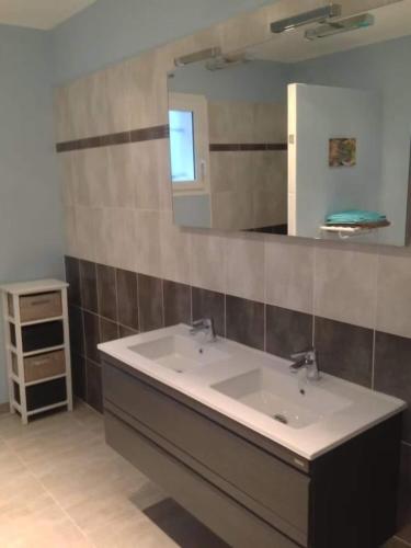 une salle de bain avec un lavabo et un miroir dans l'établissement Belle maison avec piscine et terrain entièrement clôturé, à Saint-Privat-de-Champclos