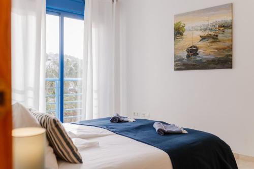 ein Schlafzimmer mit einem Bett mit blauen Laken und einem Fenster in der Unterkunft Blue Nautico - penthouse with stunning views of La Herradura in La Herradura