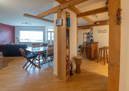 une salle à manger et un salon avec une table et des chaises dans l'établissement Vaste loft face à la plage, vue mer, à Plougonvelin