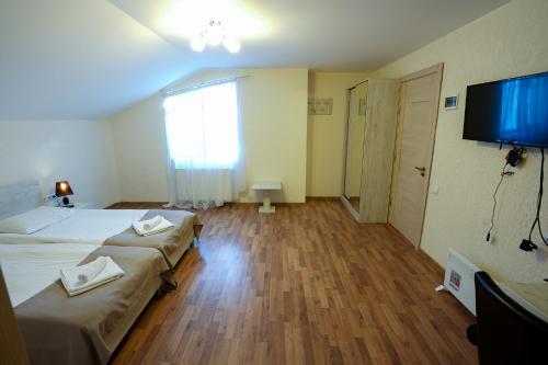 a hotel room with two beds and a flat screen tv at Soncho Gudauri in Gudauri