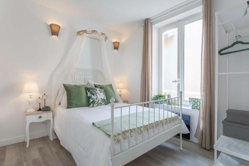une chambre blanche avec un lit blanc et une fenêtre dans l'établissement Le Bel Ombre, à Lyon