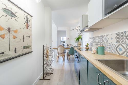 une cuisine avec des armoires bleues et une salle à manger dans l'établissement Le Bel Ombre, à Lyon