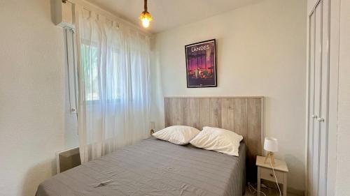 une chambre avec un lit et une fenêtre dans l'établissement La baïne, à Mimizan-Plage