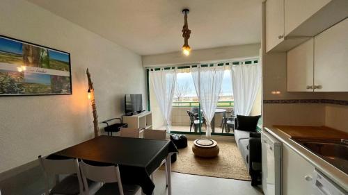 une cuisine et un salon avec une table et des chaises dans l'établissement La baïne, à Mimizan-Plage