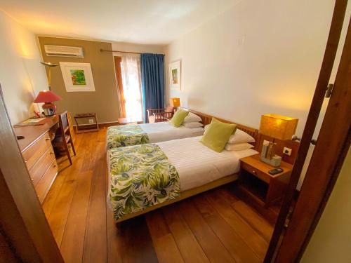 a hotel room with a bed and a desk at Palissandre ANTANANARIVO in Antananarivo