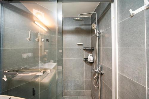 a bathroom with a shower with a glass door at 柃居 B&B - Jing'an Temple Branch in Shanghai