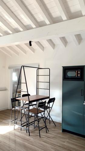 a table and chairs in a room with a refrigerator at Láurea Ecocasona in Oreña