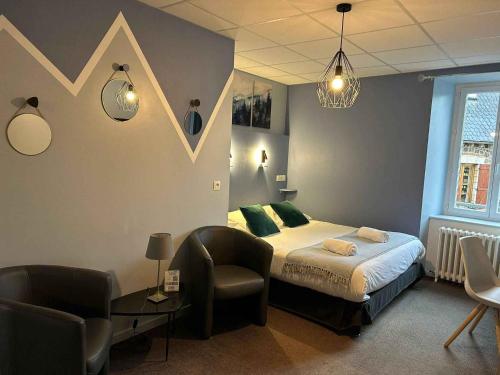 a bedroom with a bed and a chair at Logis Hôtel de Paris in Murol