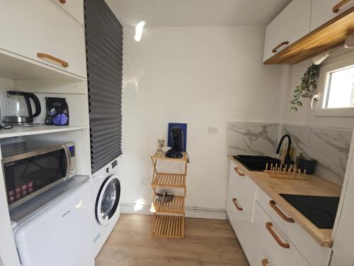 une cuisine avec des armoires blanches et un micro-ondes dans l'établissement Studio moderne et calme, à Gréoux-les-Bains