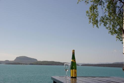 a bottle of wine and a glass sitting on a table at Koselig feriehus ved fjorden med panorama utsikt in Hjelmeland
