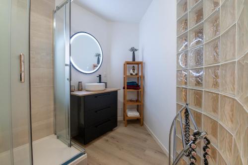 une salle de bain avec un lavabo et un miroir dans l'établissement Vaste loft face à la plage, vue mer, à Plougonvelin