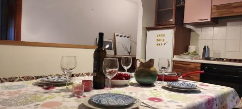 - une table avec 2 verres à vin et une bouteille dans l'établissement Bilocale relax in Cesana, à Césane