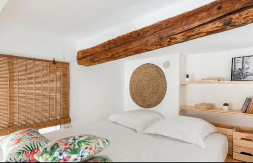 une chambre blanche avec un lit et une fenêtre dans l'établissement Appartement authentique au centre d'Antibes, à Antibes