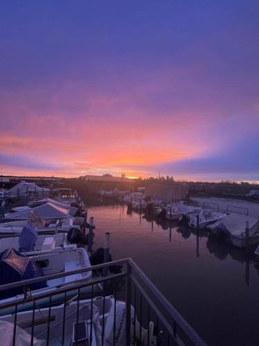a sunset over a marina with boats in the water at Rifugio Punta Maestra in Pila