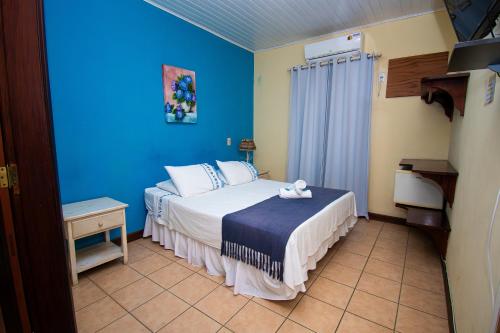 a bedroom with a bed in a blue room at Pousada Brisa de Paraty in Paraty