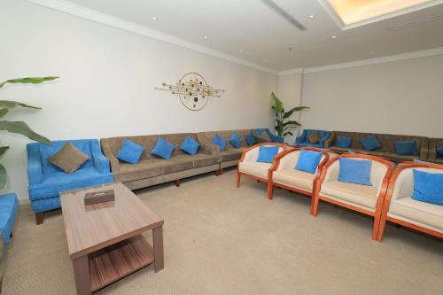 a waiting room with a couch and blue chairs at Dimond Vision Hotel in Jeddah
