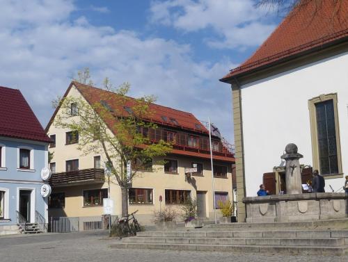 a building with a statue in front of a building at Rotes Ross in Burghaslach