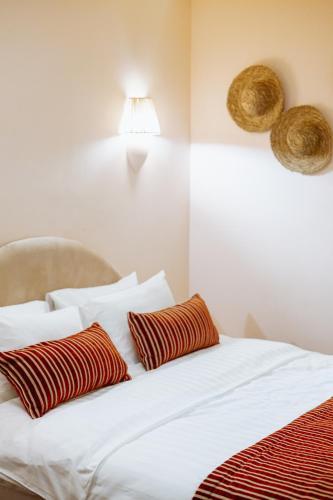 a bed with two red and white pillows on it at Nekresi Estate in Kvareli